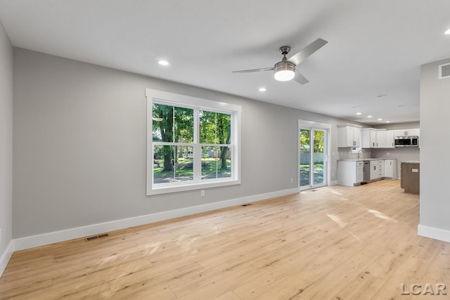 unfurnished living room with ceiling fan, light hardwood / wood-style floors, and a wealth of natural light