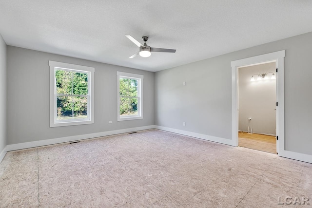 unfurnished room with ceiling fan and a textured ceiling