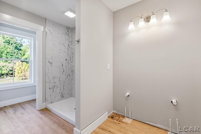 bathroom featuring hardwood / wood-style floors and tiled shower