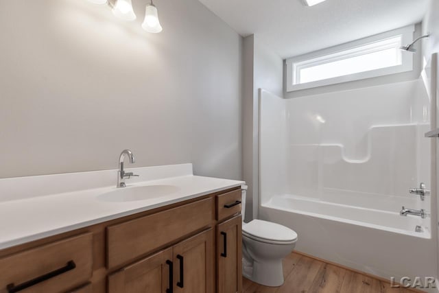 full bathroom with vanity, wood-type flooring, toilet, a textured ceiling, and shower / bath combination