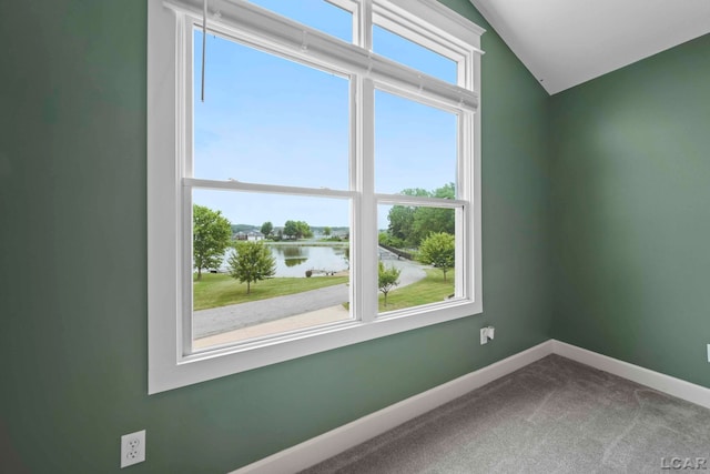 unfurnished room featuring carpet, a water view, and lofted ceiling