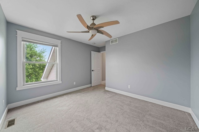 unfurnished room with ceiling fan and carpet