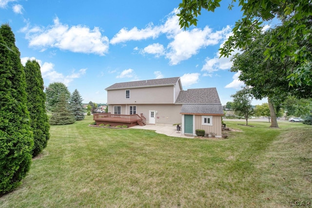 rear view of property with a yard, an outdoor structure, and a deck