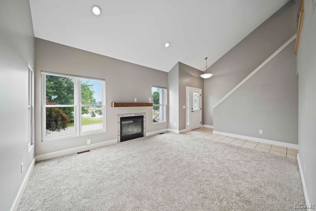 unfurnished living room with light carpet and vaulted ceiling