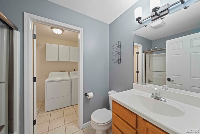 bathroom featuring vanity, tile patterned floors, toilet, separate washer and dryer, and walk in shower