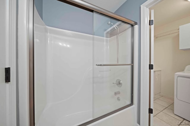 bathroom with tile patterned flooring, washer / dryer, and shower / bath combination with glass door