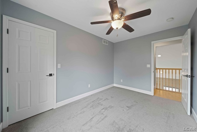 unfurnished bedroom with ceiling fan and light carpet