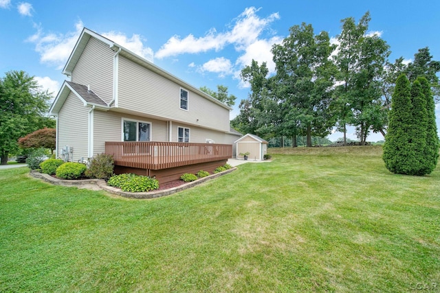 rear view of property featuring a lawn, a wooden deck, and a storage shed