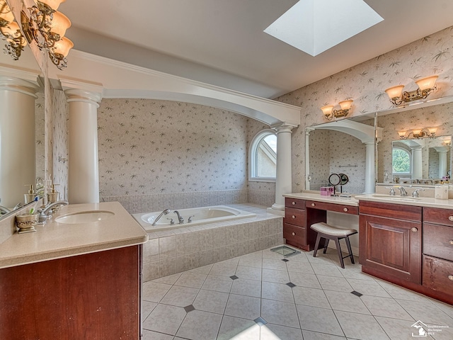 bathroom featuring tile patterned floors, vanity, ornate columns, and a healthy amount of sunlight