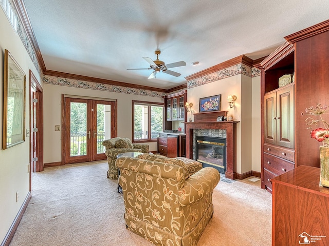 carpeted living room featuring french doors, a textured ceiling, ceiling fan, and ornamental molding