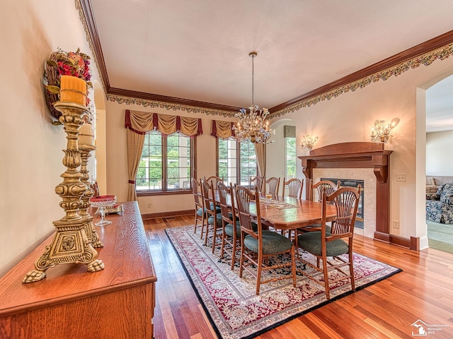 dining room with crown molding, hardwood / wood-style floors, and a notable chandelier