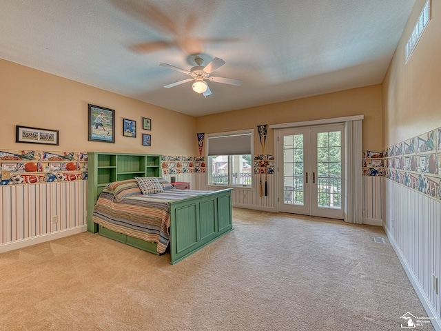 bedroom featuring access to exterior, ceiling fan, light carpet, and a textured ceiling