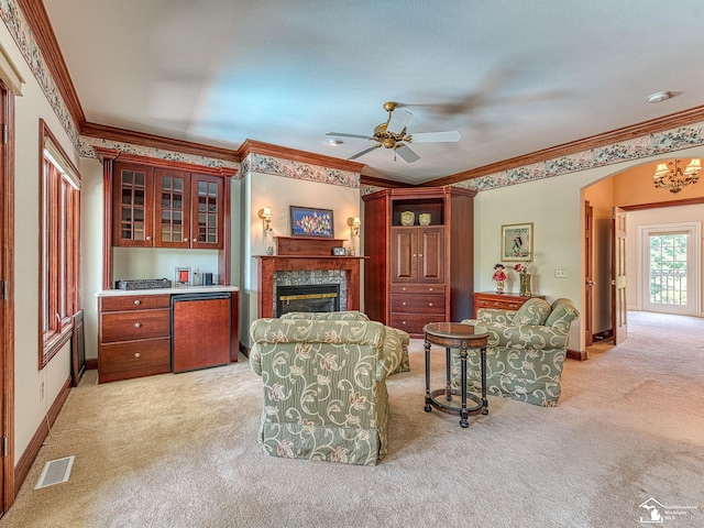 living room featuring ceiling fan, ornamental molding, and light carpet