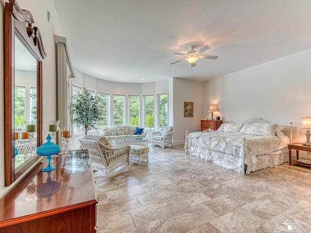 bedroom with ceiling fan, a textured ceiling, and multiple windows