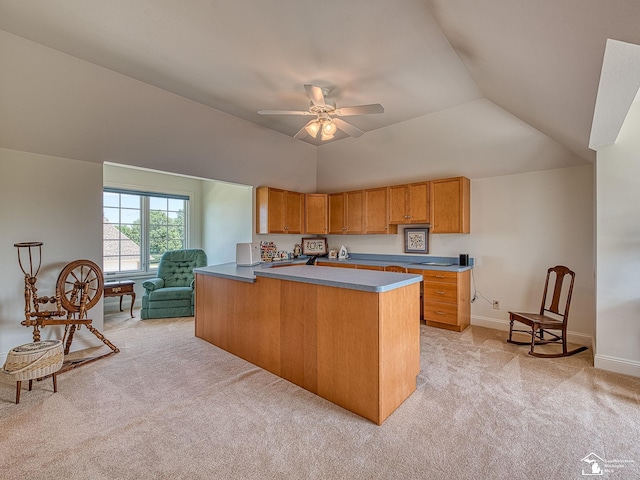 kitchen featuring ceiling fan, light colored carpet, kitchen peninsula, and vaulted ceiling