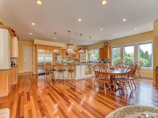 dining space featuring sink, light hardwood / wood-style floors, and a textured ceiling