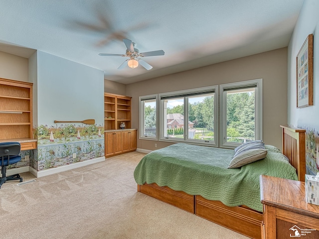 bedroom with multiple windows, ceiling fan, and light carpet