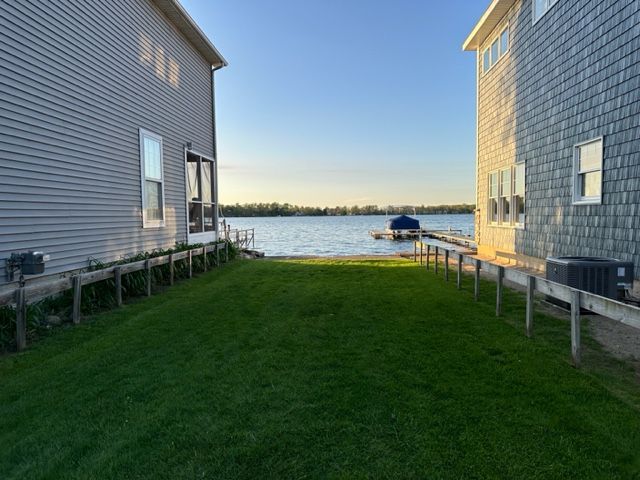 view of yard with a water view and central air condition unit