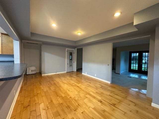 unfurnished living room featuring french doors and light hardwood / wood-style floors