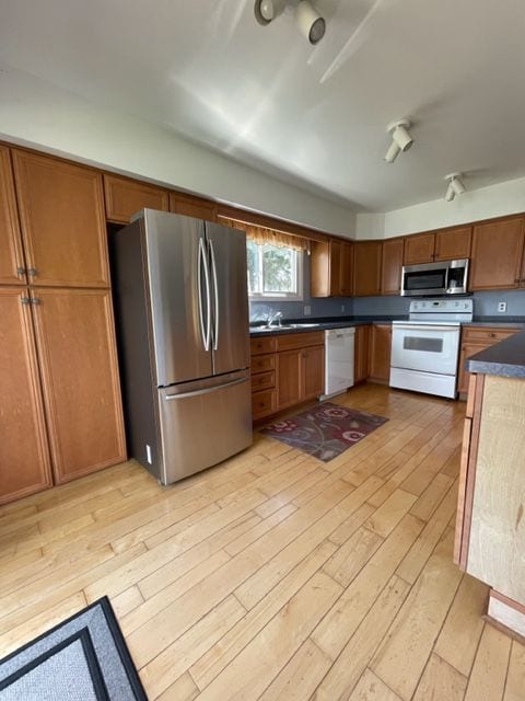 kitchen with sink, light wood-type flooring, and stainless steel appliances