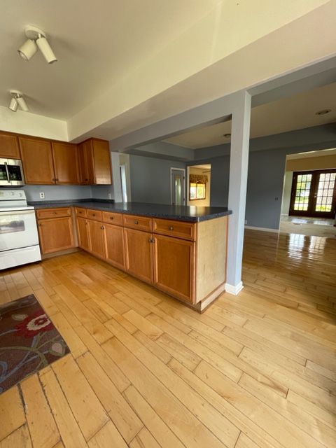 kitchen with white range with electric cooktop and light hardwood / wood-style floors