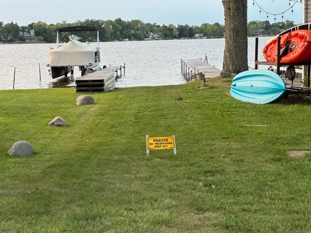 dock area featuring a lawn and a water view