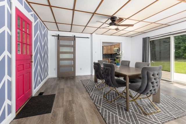 interior space with a barn door and ceiling fan