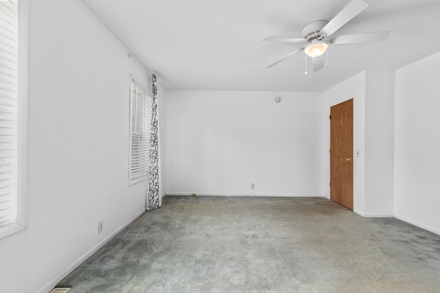 carpeted spare room with ceiling fan