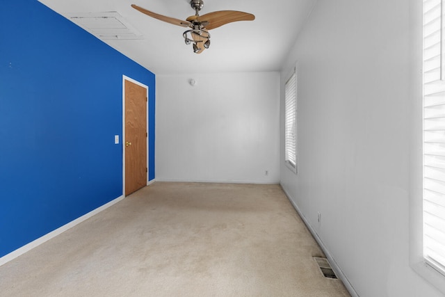 unfurnished room with ceiling fan, light colored carpet, and a wealth of natural light