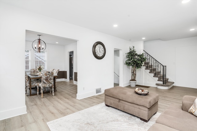 living room featuring light wood-type flooring and a chandelier