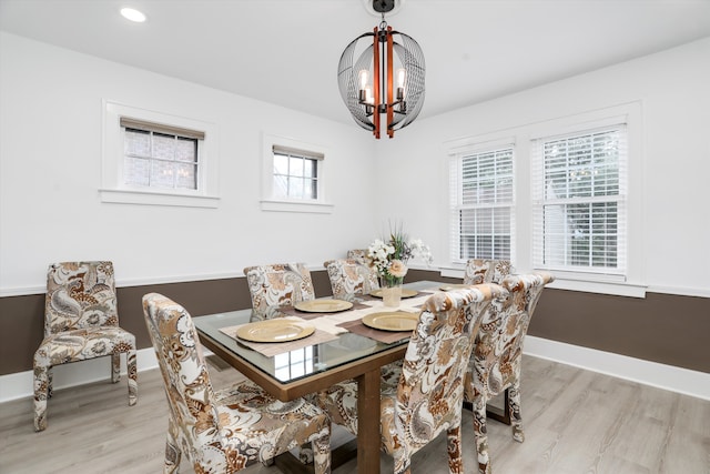 dining area featuring light wood-type flooring and an inviting chandelier