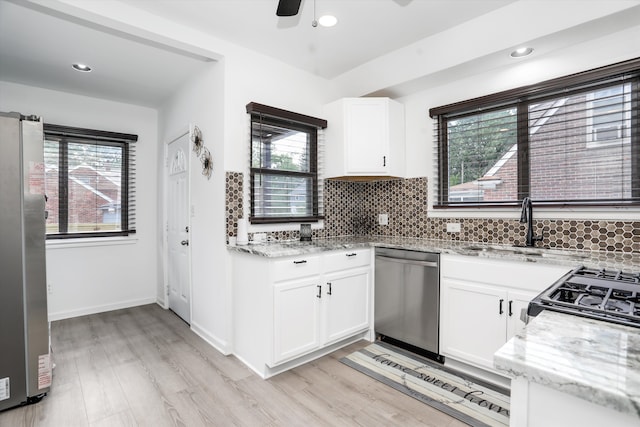 kitchen featuring white cabinets, stainless steel appliances, and a wealth of natural light