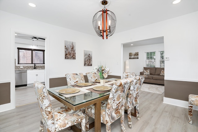 dining space featuring plenty of natural light, ceiling fan with notable chandelier, and light wood-type flooring