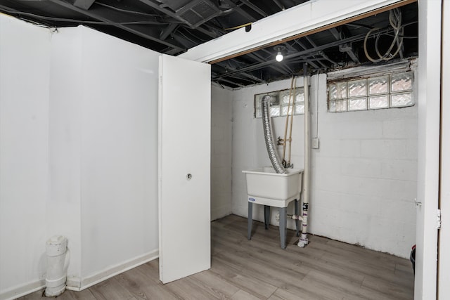 basement featuring sink and wood-type flooring