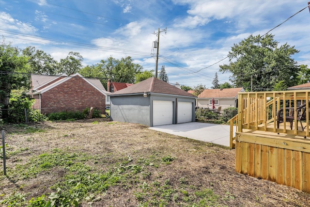 exterior space featuring a garage, an outbuilding, and a wooden deck