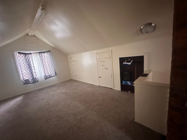 bonus room with dark carpet and vaulted ceiling