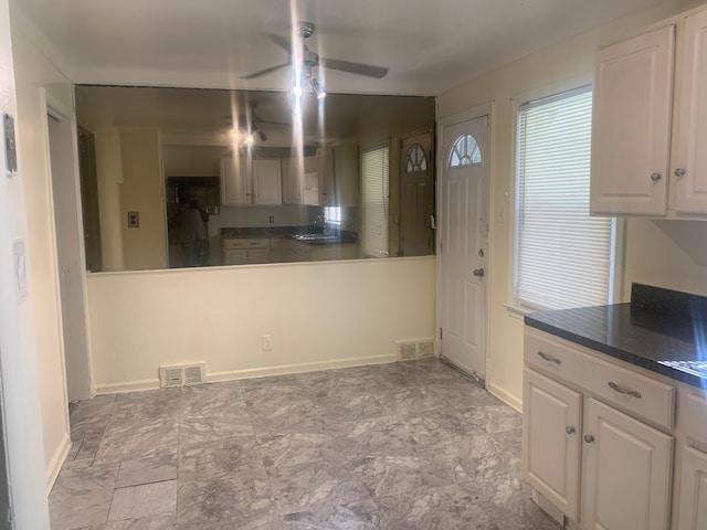 kitchen featuring white cabinetry, sink, and ceiling fan