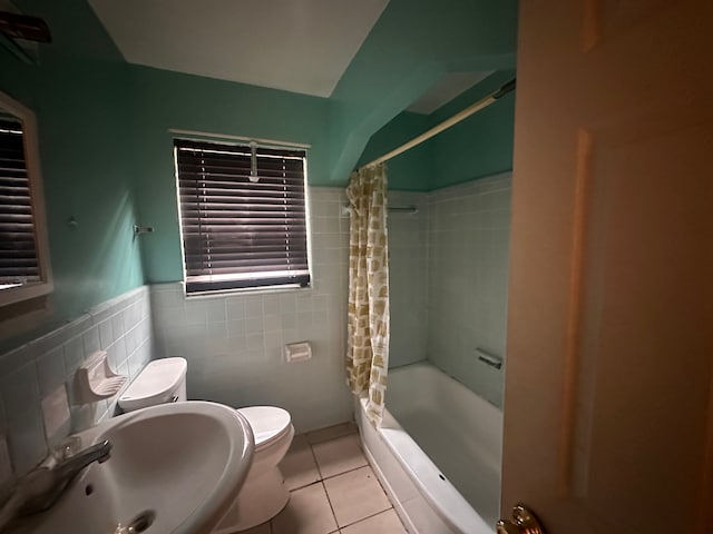 full bathroom featuring shower / bath combo, tile patterned floors, sink, tile walls, and toilet