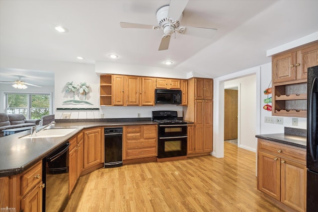 kitchen featuring sink, vaulted ceiling, light wood-type flooring, ceiling fan, and black appliances