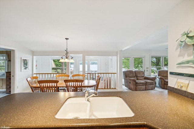 kitchen with sink, pendant lighting, and a notable chandelier