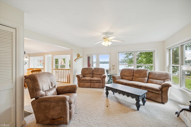 carpeted living room with ceiling fan