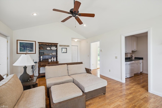 living room with ceiling fan, lofted ceiling, sink, and light wood-type flooring