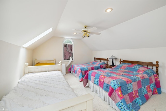 bedroom with ceiling fan, vaulted ceiling with skylight, and carpet