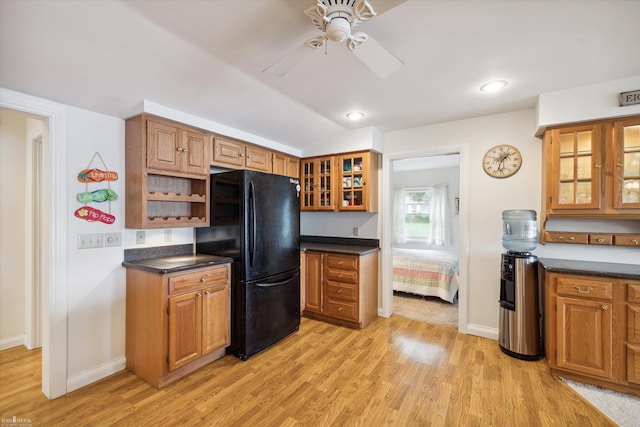 kitchen featuring lofted ceiling, light wood-type flooring, ceiling fan, and black fridge