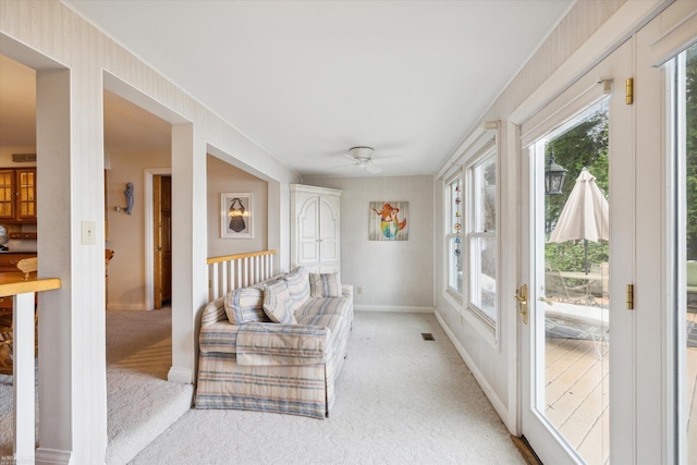 interior space with ceiling fan and light carpet