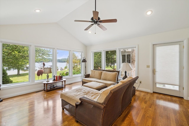 interior space with hardwood / wood-style flooring, a water view, ceiling fan, and vaulted ceiling