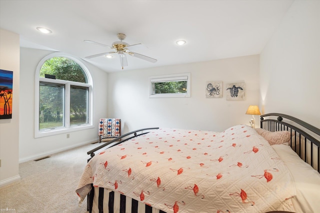 carpeted bedroom with multiple windows and ceiling fan