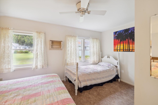 carpeted bedroom featuring multiple windows and ceiling fan