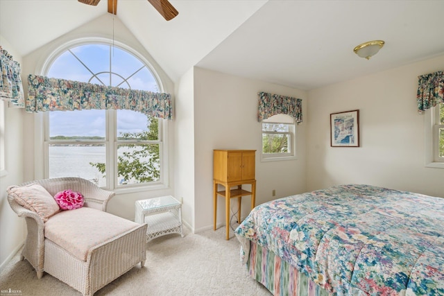 bedroom with light carpet, vaulted ceiling, ceiling fan, and a water view