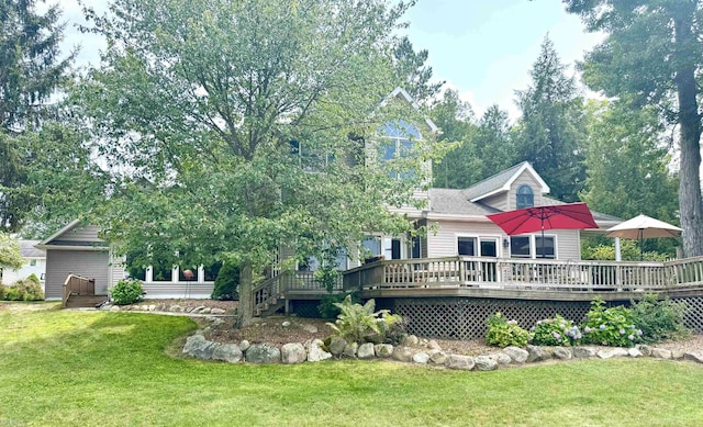 rear view of house with a wooden deck and a lawn